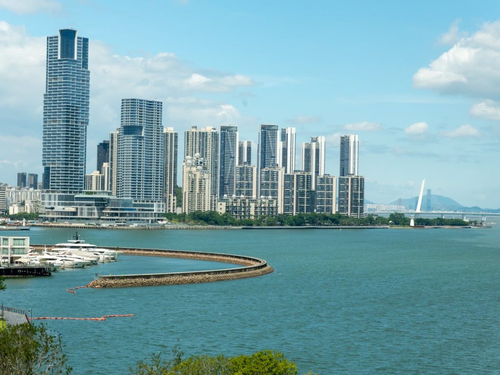 Captivating view of Shenzhen skyline with towering skyscrapers along the waterfront under a bright blue sky.
